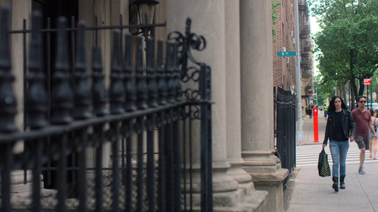 Jessica walks along the sidewalk back to her apartment building.
