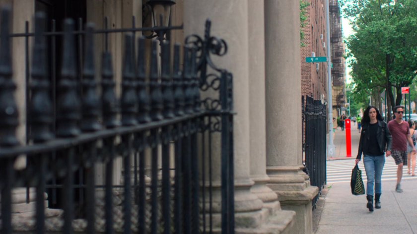 Jessica walks along the sidewalk back to her apartment building.