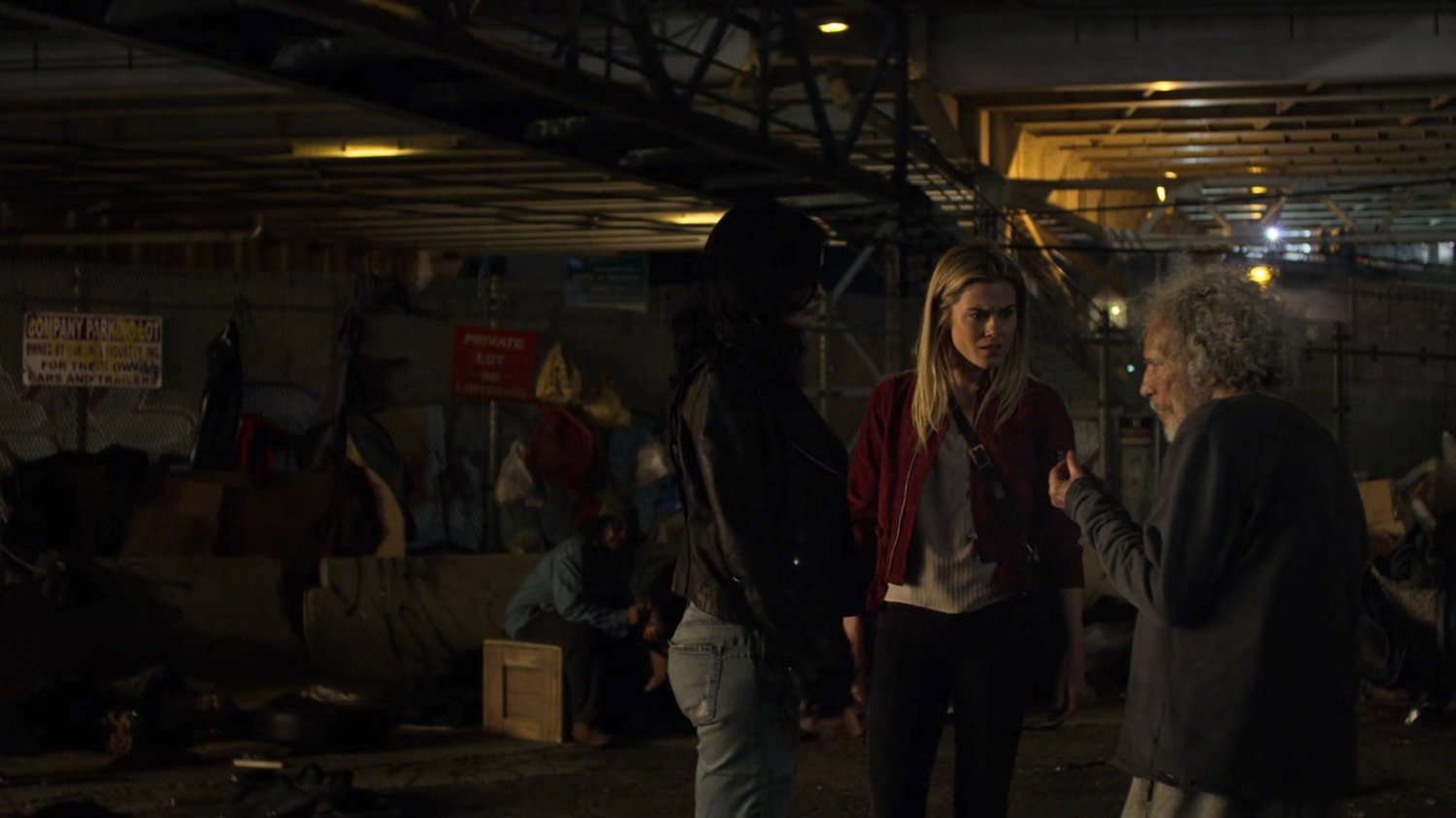 Trish and Jessica at a homeless encampment at night.