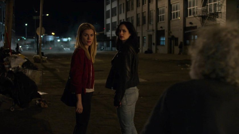 Trish and Jessica outside a homeless encampment at night.