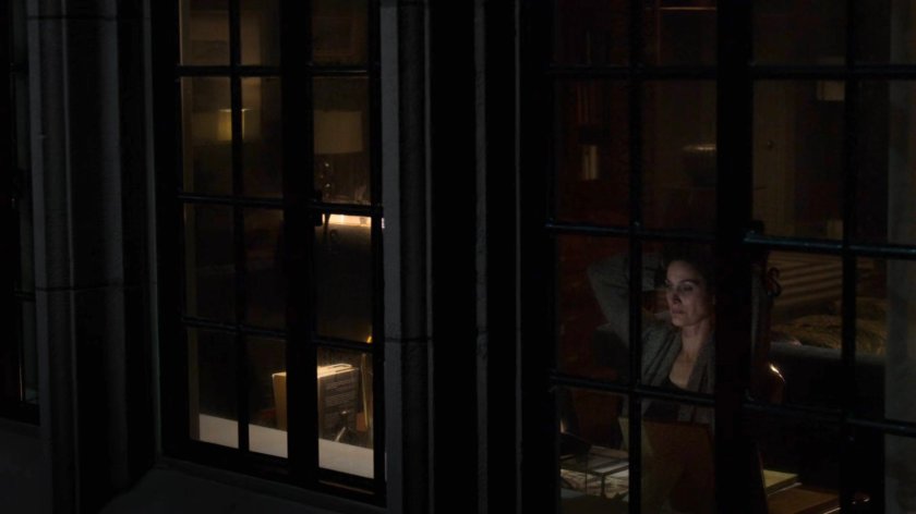 Jeri looking out the window of her apartment.