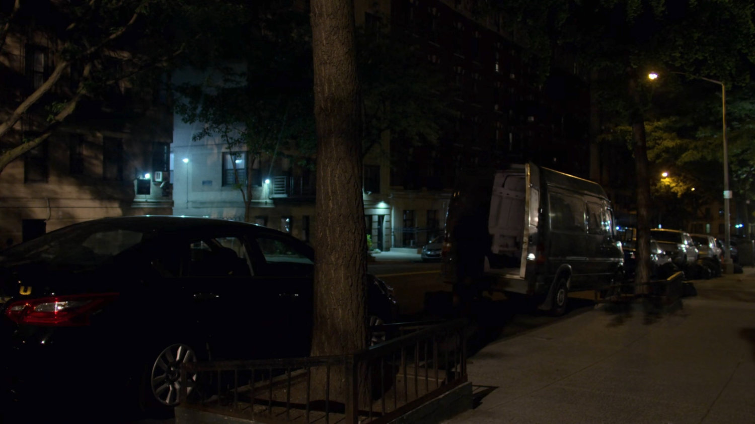 Cars parked on the street outside Jessica's building.