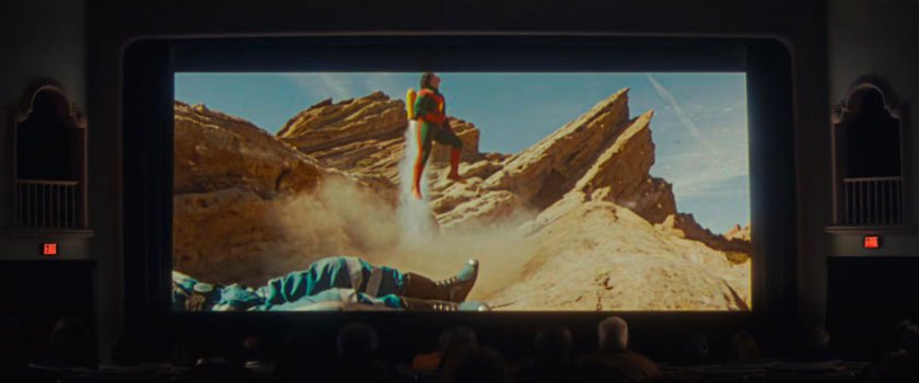 A movie screen showing Wonder Man blasting off with his jet pack.