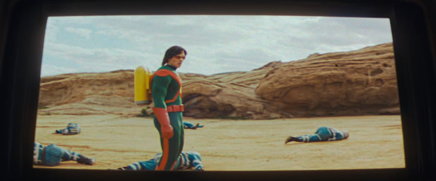 Movie screen showing Wonder Man standing by downed aliens on an alien planet.