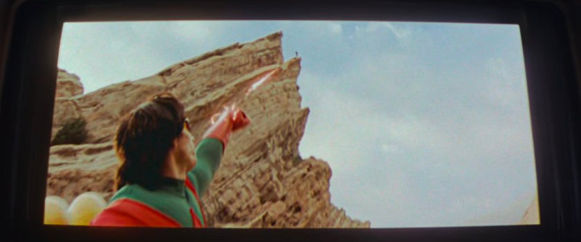 Movie screen showing Wonder Man firing at an alien on an alien planet.
