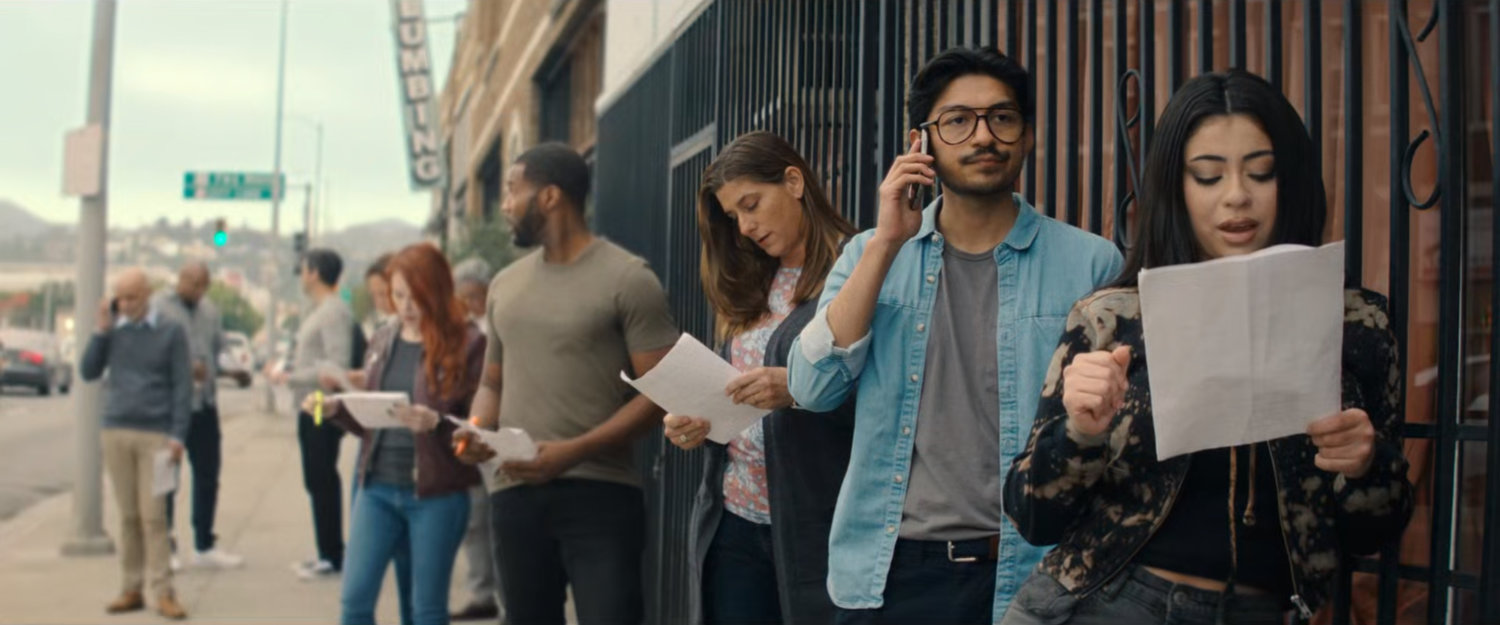 Actors in line for an audition on a sidewalk.