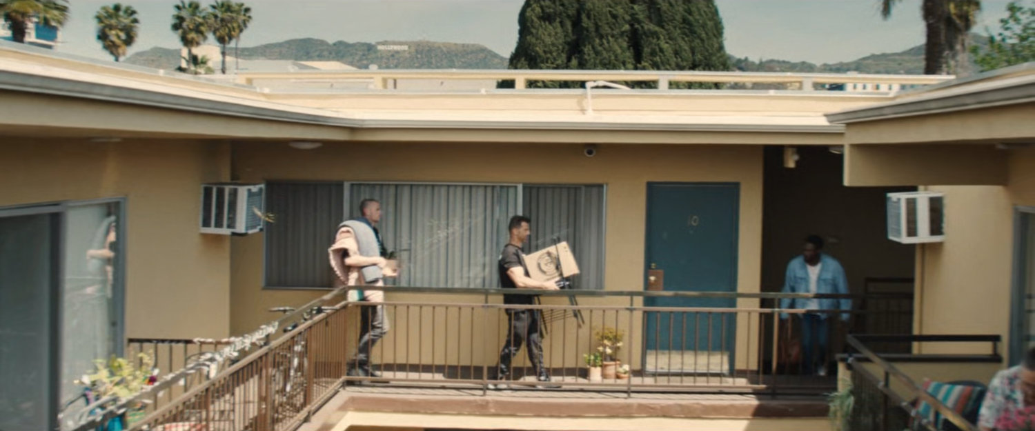 Upper balcony of Simon's apartment building with Hollywood sign in background.