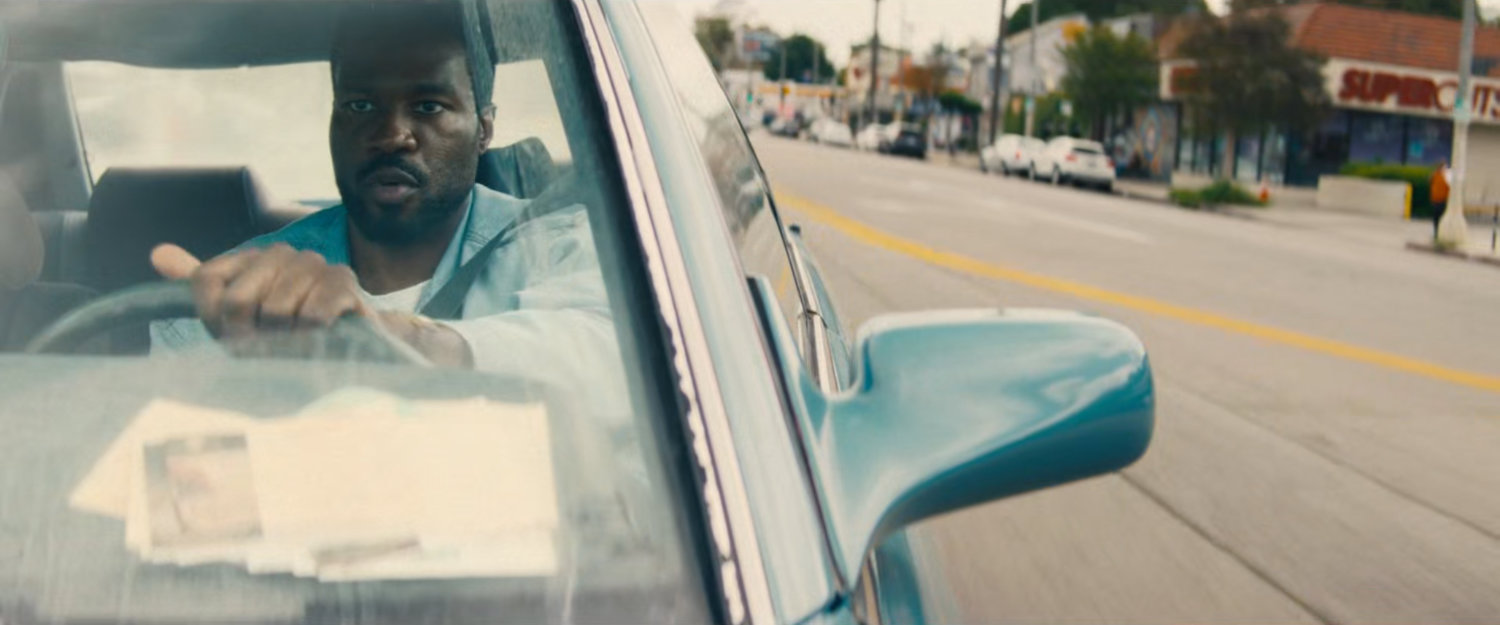Simon driving his car on a Hollywood street.