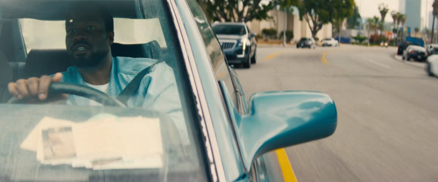 Simon driving his car on a Hollywood street.