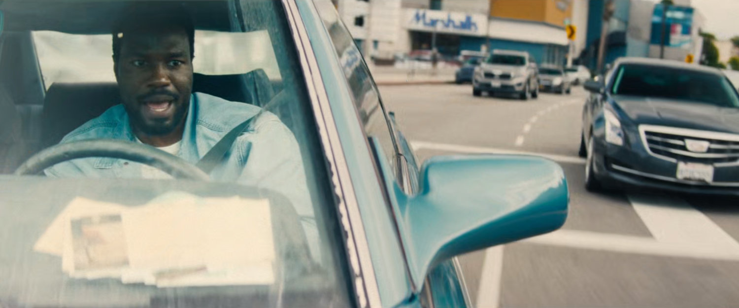 Simon driving his car on a Hollywood street.