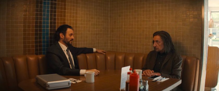 Agent Cleary and Trevor in a booth at a diner.