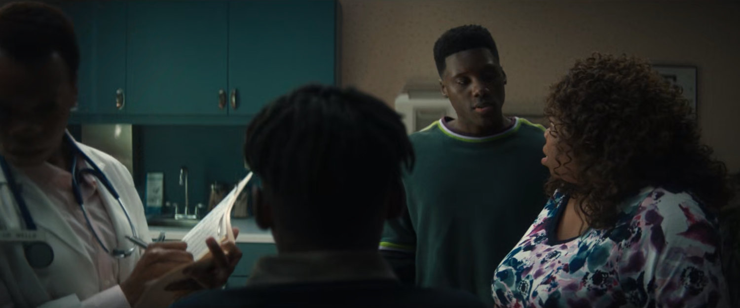 Young Simon and young Eric with their mother and a doctor in an examining room.