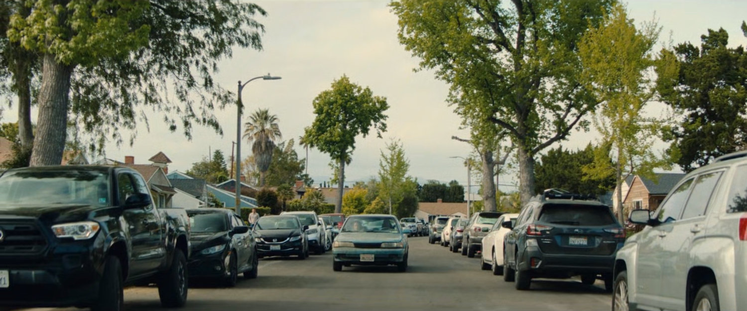 Simon's car driving along a crowded Pacoima street.