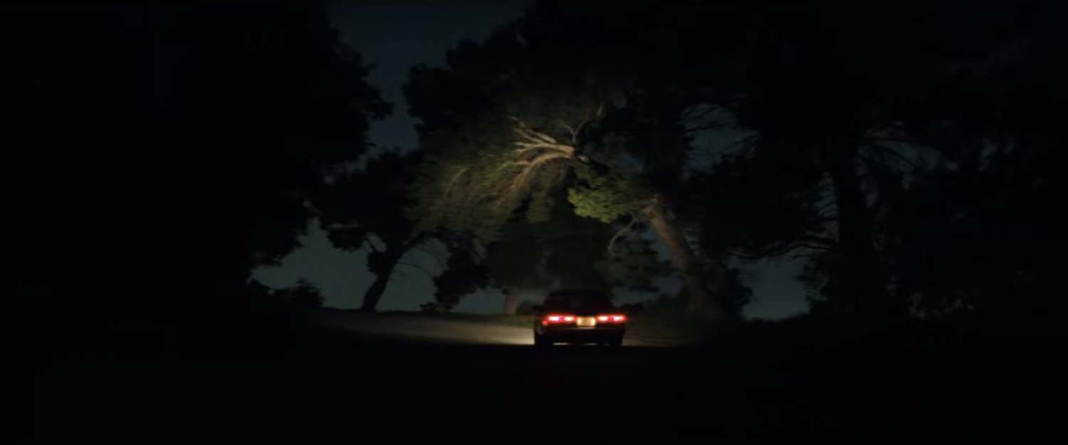 Simon's car on a dark hilly road.