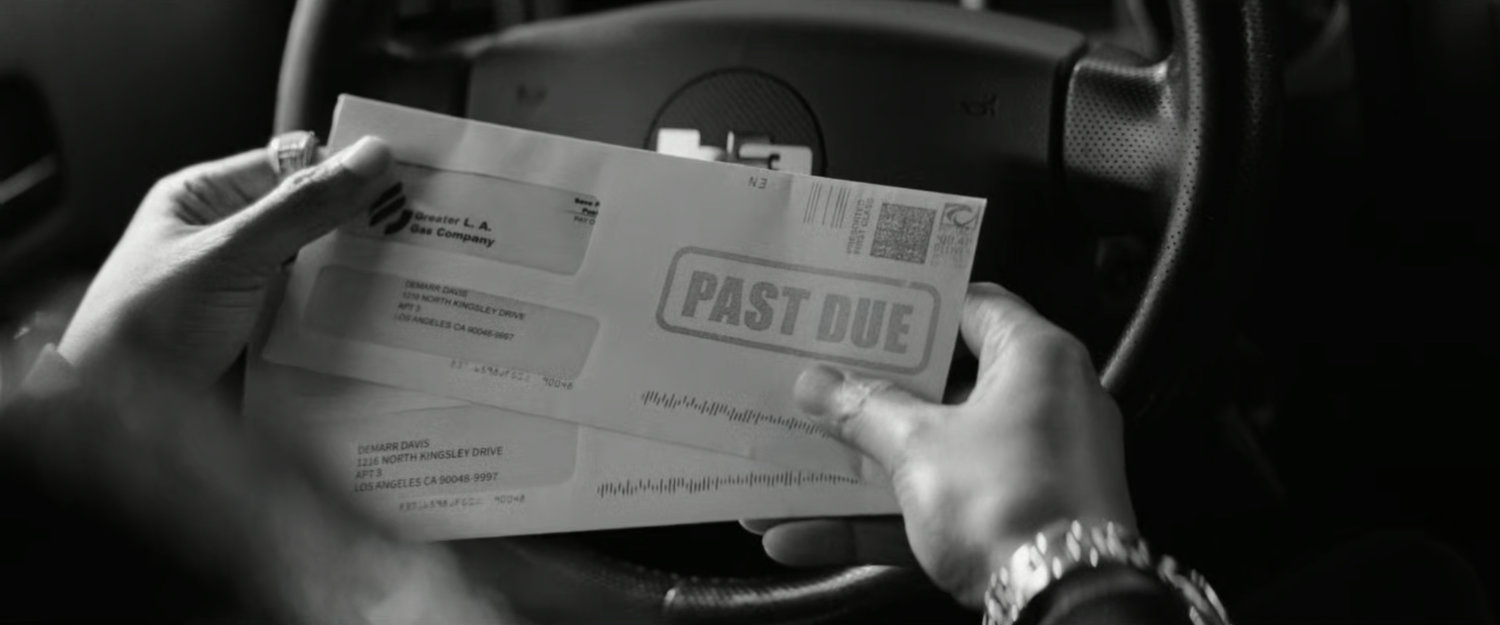 DeMarr looking at his past due bills while sitting in his car.