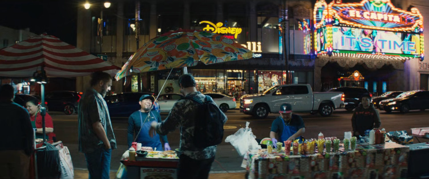 Nighttime view of vendors on sidewalk in front of El Capitan Theater.