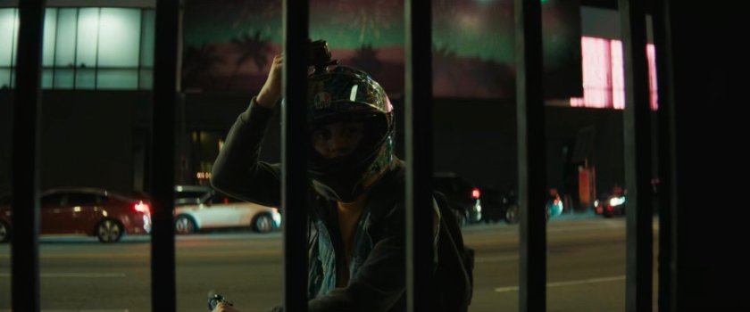 Jayden watching the fight through the gate of the alley.