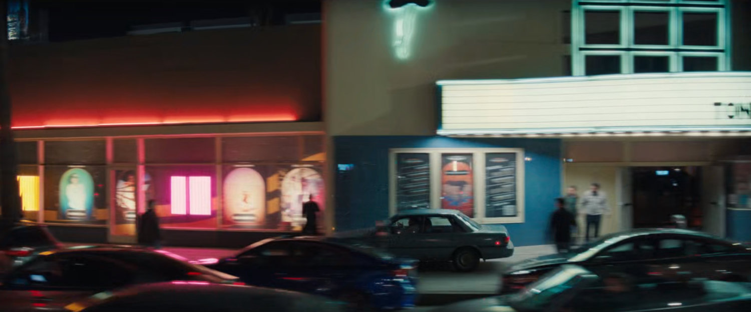 Simon driving his car along the sidewalk outside the Palladium.