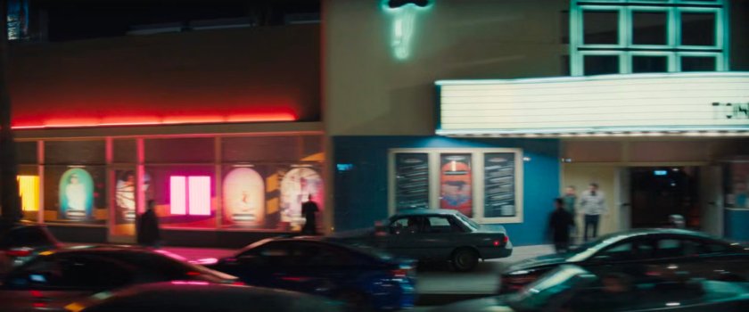 Simon driving his car along the sidewalk outside the Palladium.