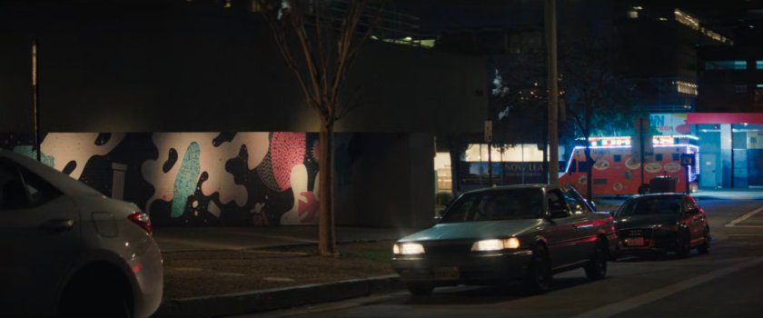 Simon's car pulling up to a parking space by a sidewalk.