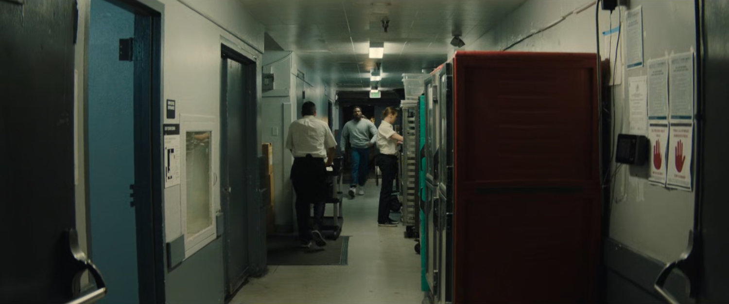 Simon walking through a back hallway of a club.