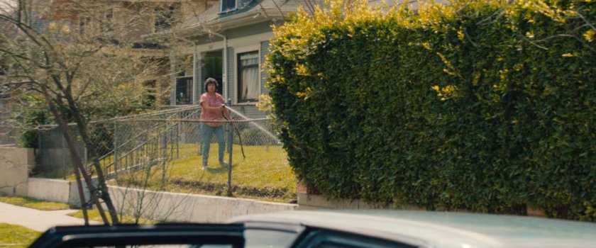 A neighbor watering her yard outside Esteban's house.