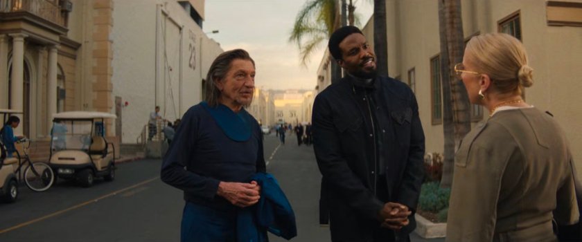 Trevor, Simon, and Kathy talk on a studio backlot.