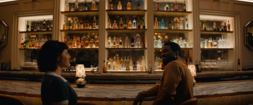 Vivian and Simon sitting at fancy bar.