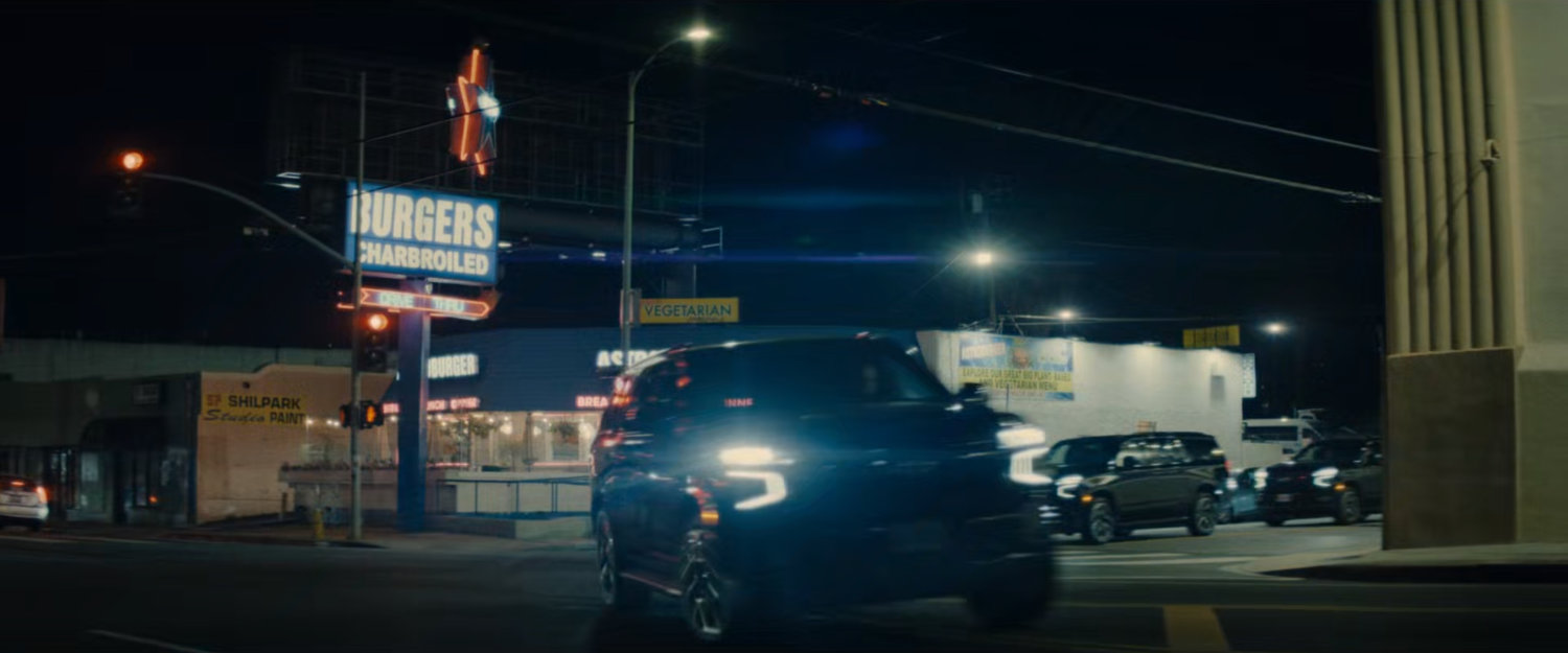 DODC SUVs race around a street corner by Astroburger.