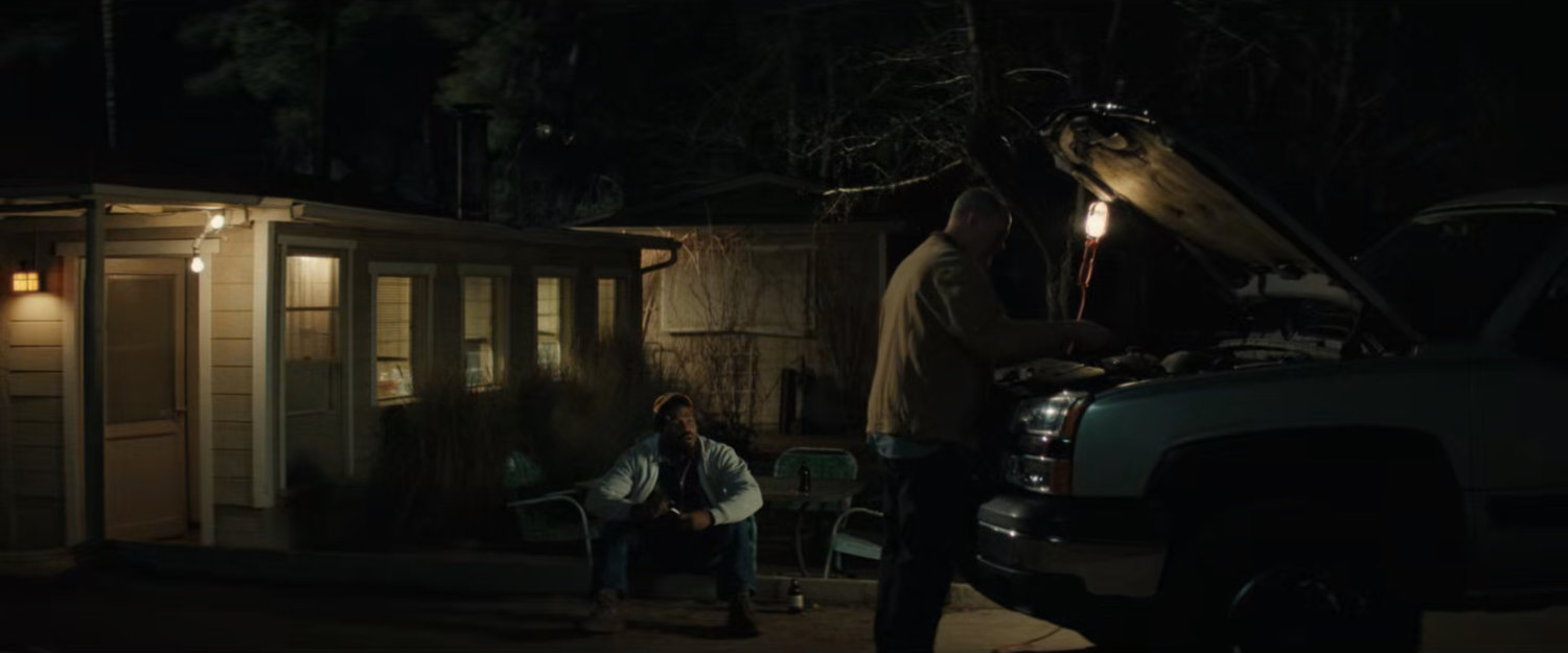 Simon watching Chuck work on his truck.
