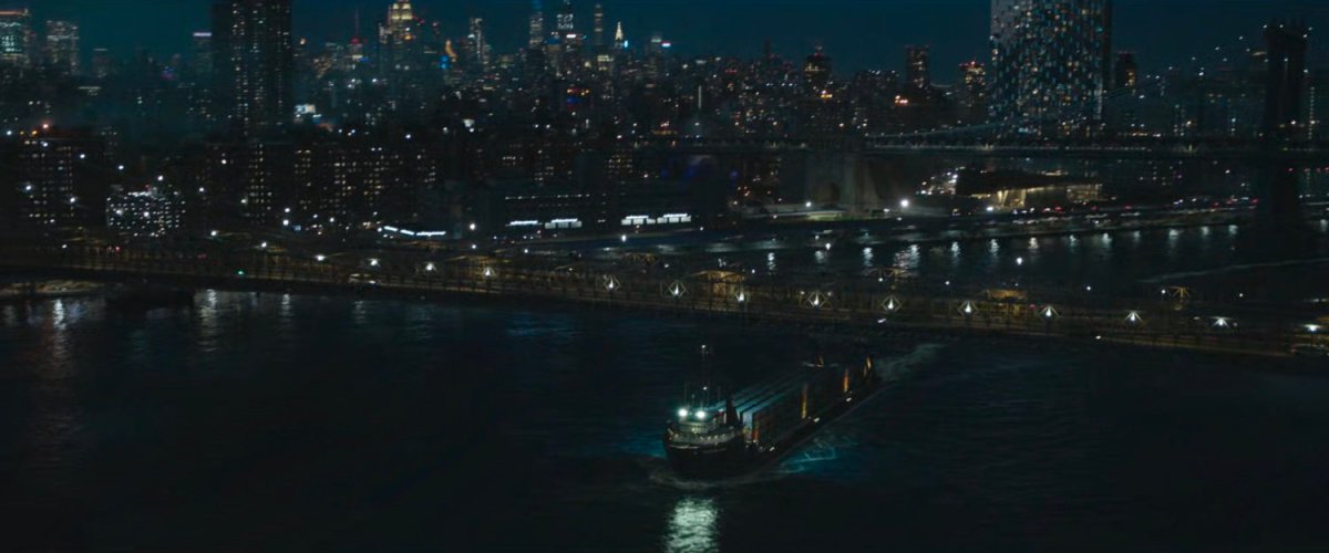 A cargo ship in the East River passing under the Brooklyn Bridge.