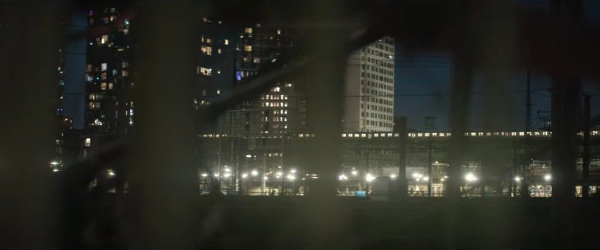Interstitial: night time view of elevated subway and apartment buildings.