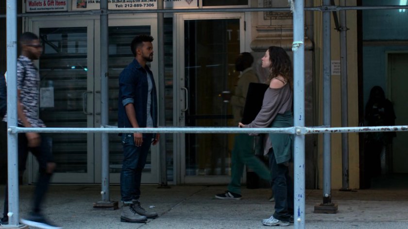 Malcolm confronting Inez outside a shop.