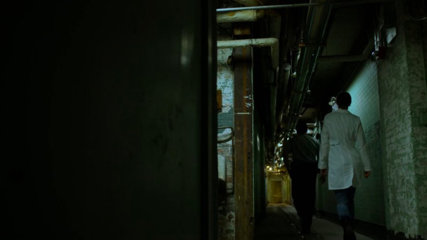 Jessica and guard in a hallway of Birch Psychiatric Hospital.