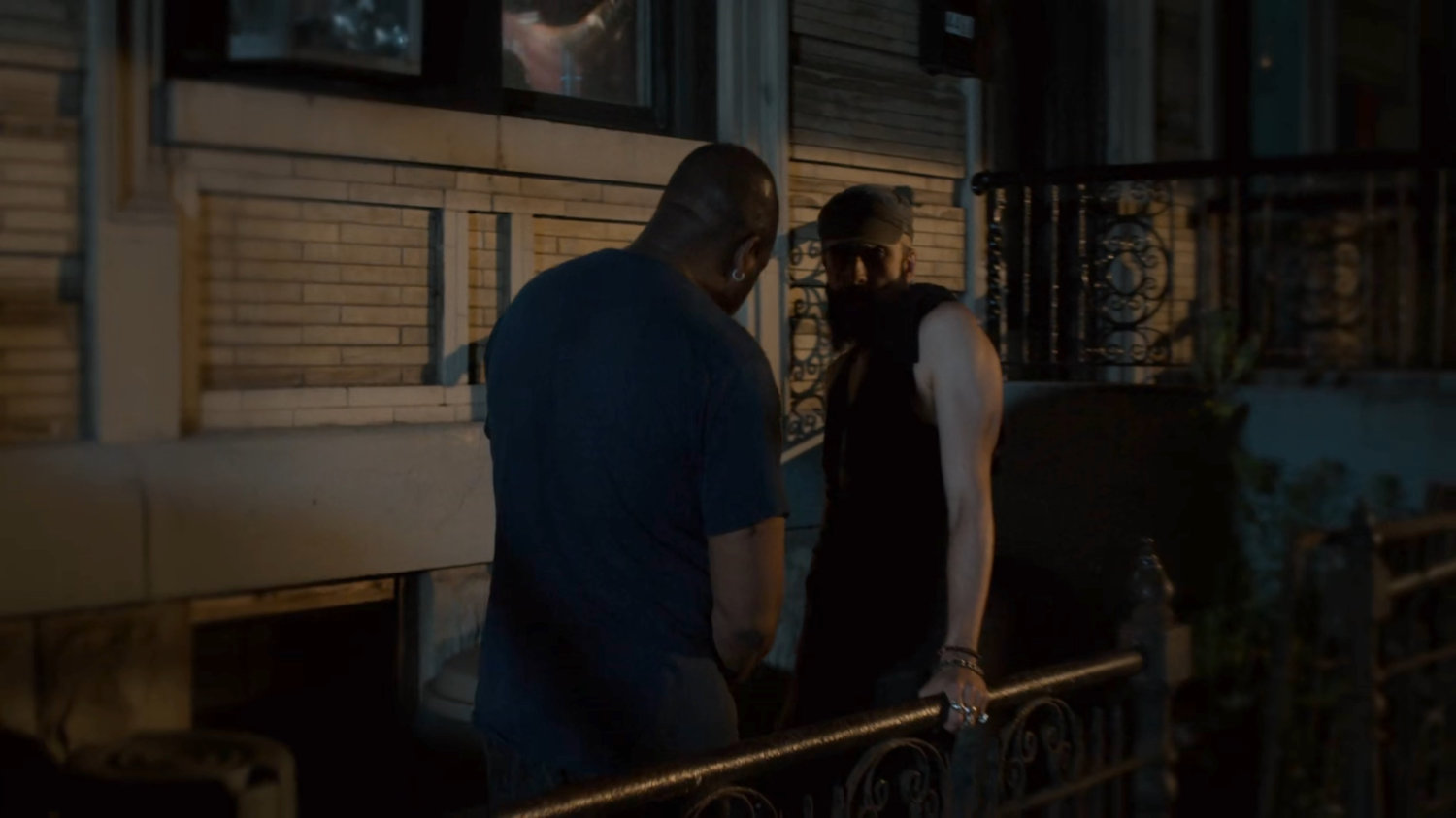Two men on a dark sidewalk.