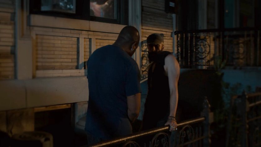 Two men on a dark sidewalk.