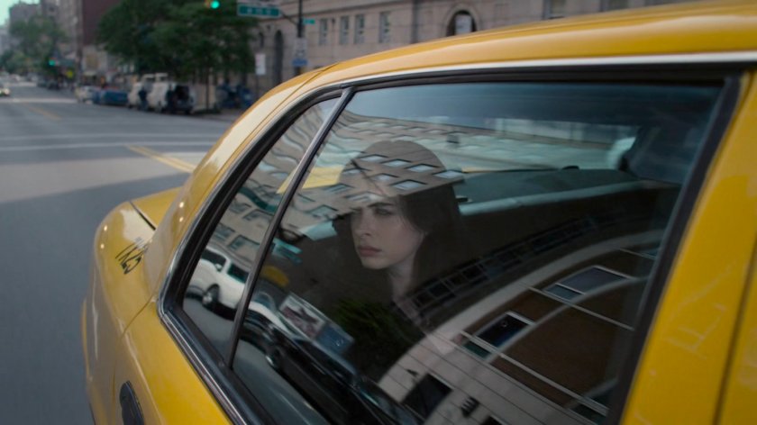 Jessica in a cab driving along New York street.