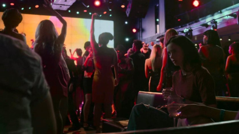 Jessica sitting in a dance club during Trish's single release party.