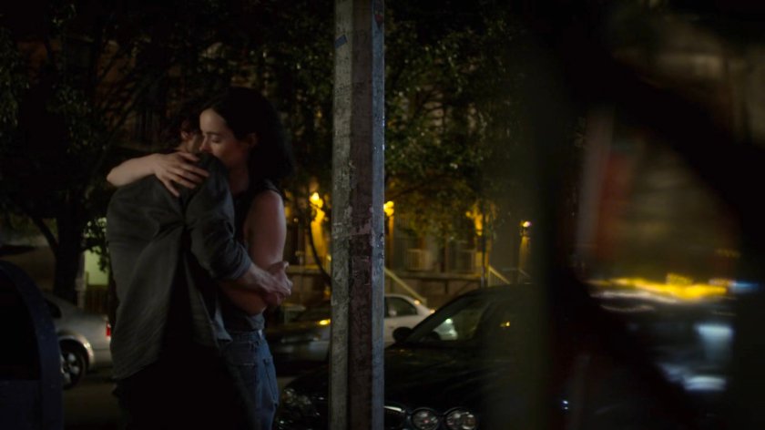 Jessica and Stirling hugging on a dark sidewalk.