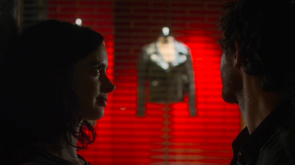 Jessica and Stirling on a dark sidewalk in front of a store window displaying a leather jacket.