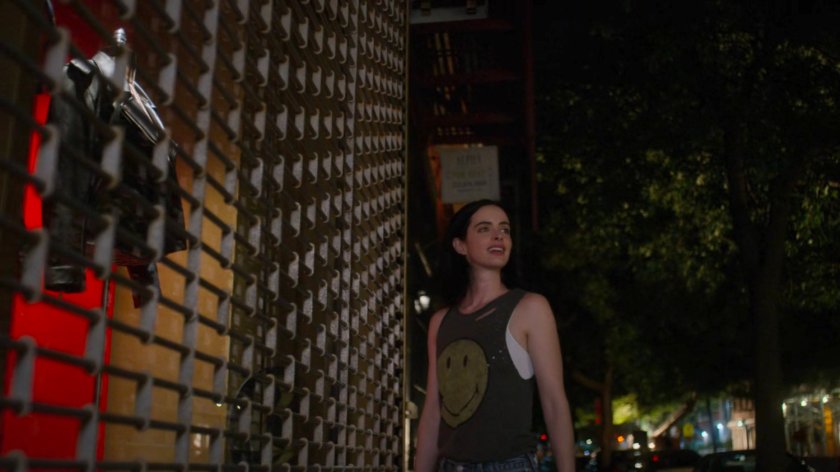Jessica standing by a locked store window displaying a leather jacket.