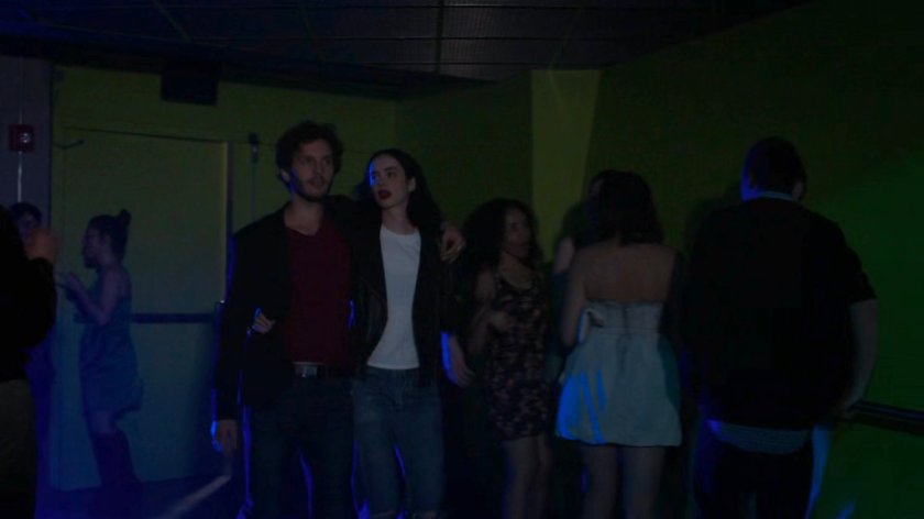 Stirling and Jessica walking through a crowded dance club.