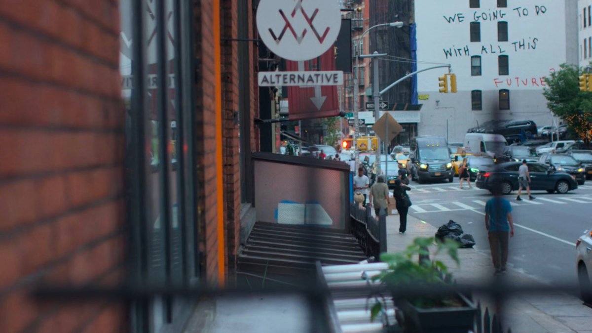 Malcolm searching for Jessica along a sidewalk.