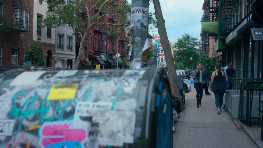 Trish searching for Jessica while on the phone along a sidewalk.