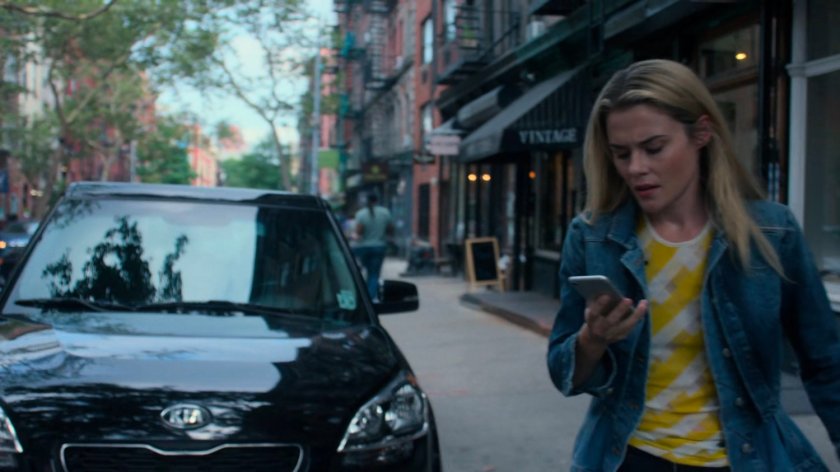 Trish searching for Jessica while on the phone along a sidewalk.