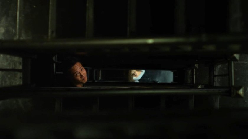 Pryce Cheng looking through an apartment stairway column.
