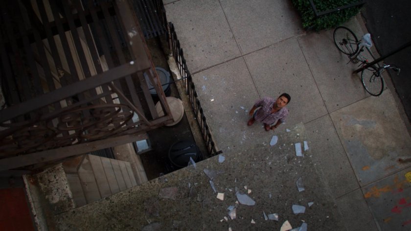 Oscar looking at broken glass outside Alias Investigations.