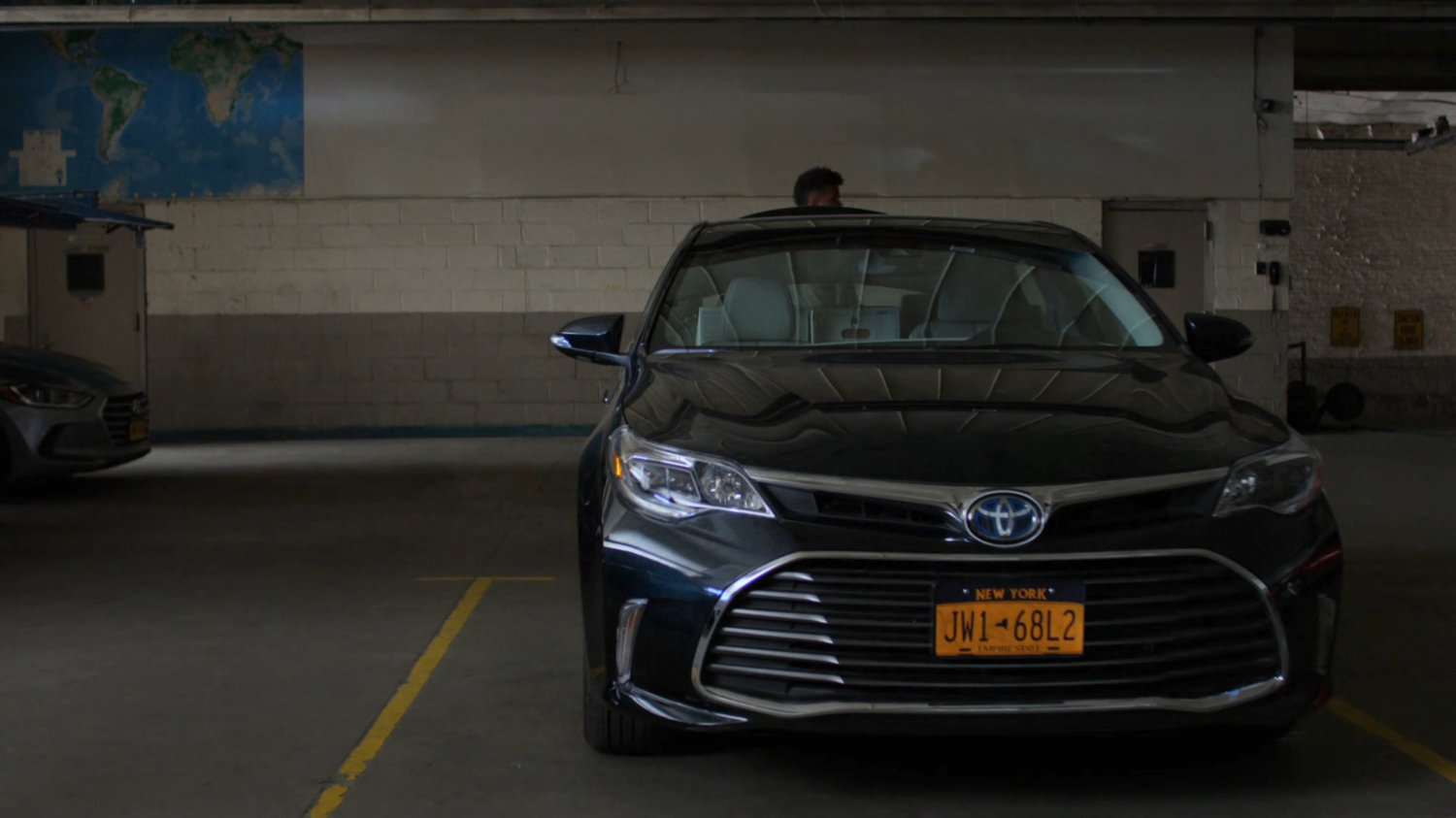 Malcolm getting out of Trish's trunk in a parking garage.