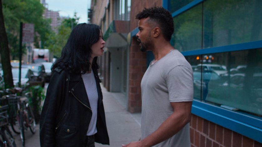 Jessica and Malcolm talking on a sidewalk.