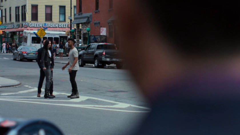 Kilgrave speaking with Malcolm and Jessica on the sidewalk.